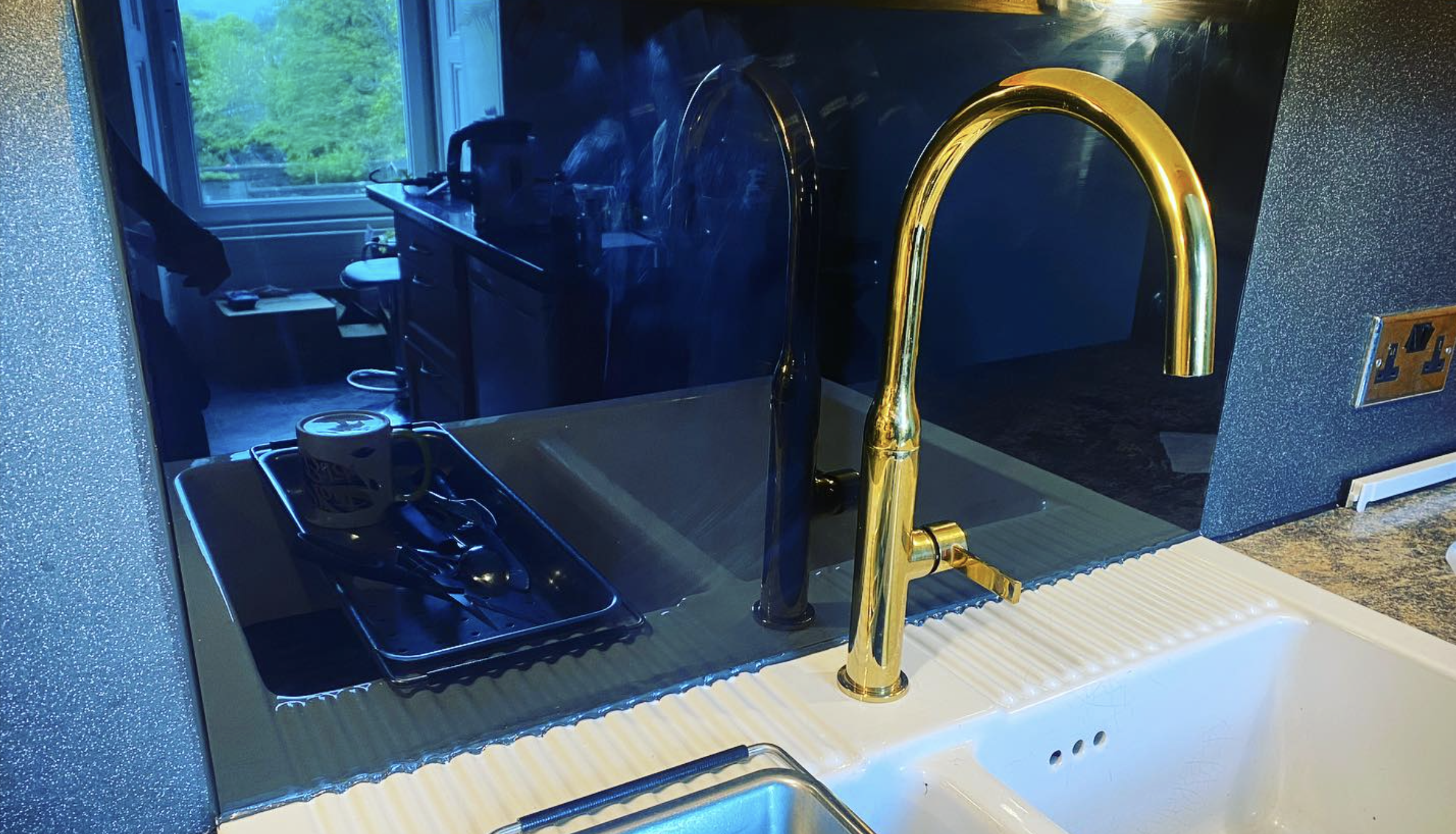 Brass kitchen mixer tap on stone worktop