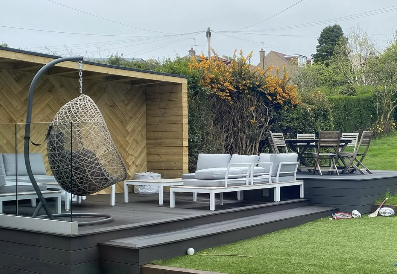 Lush garden deck with hanging chair and natural greenery