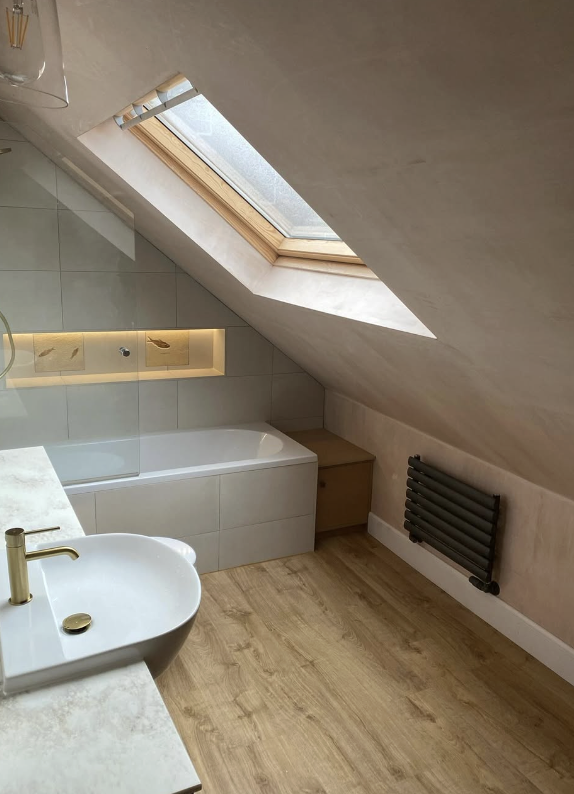 Loft bathroom with Velux skylight, vessel sink and gold tap on marble vanity top