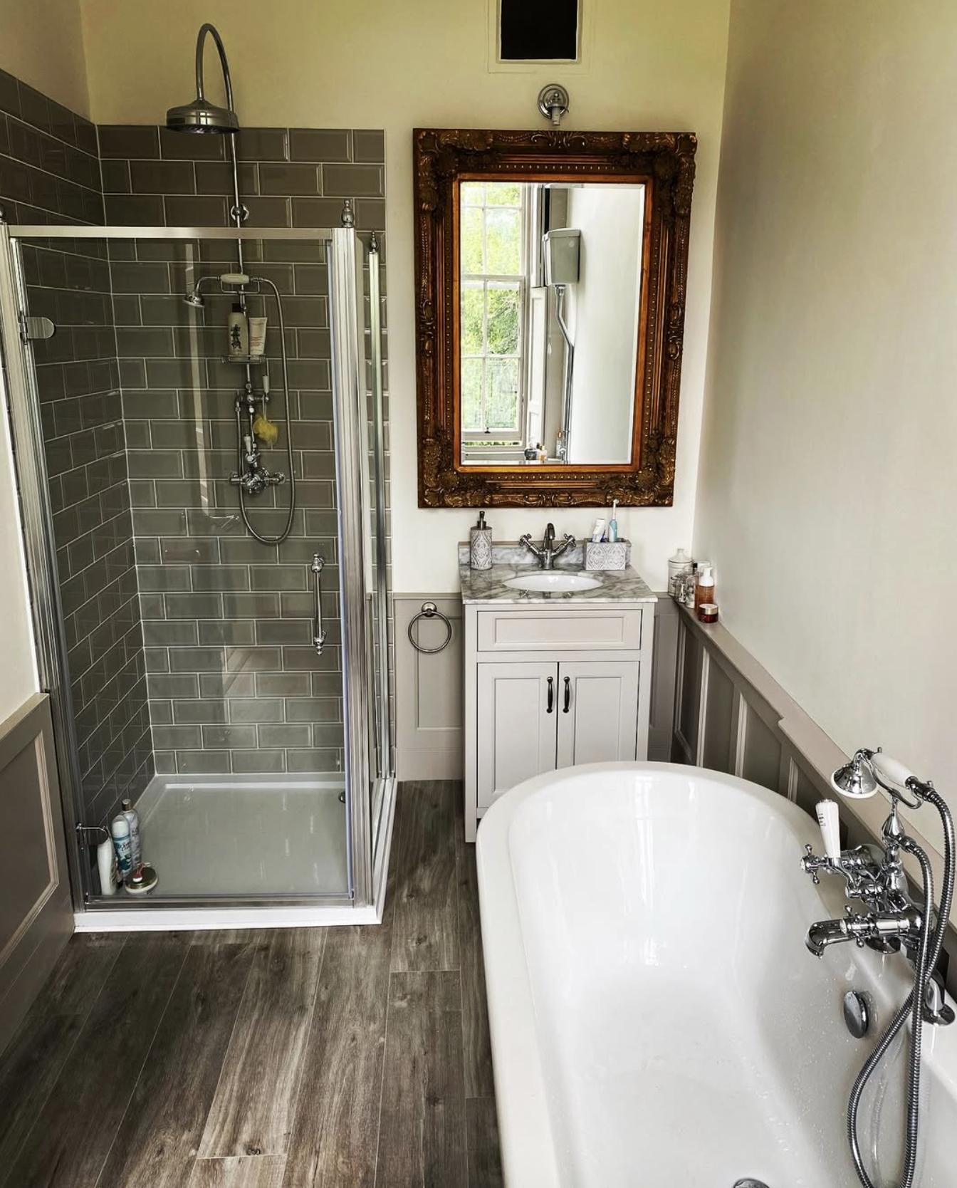 Traditional bathroom with freestanding bath, grey metro tiles and ornate mirror
